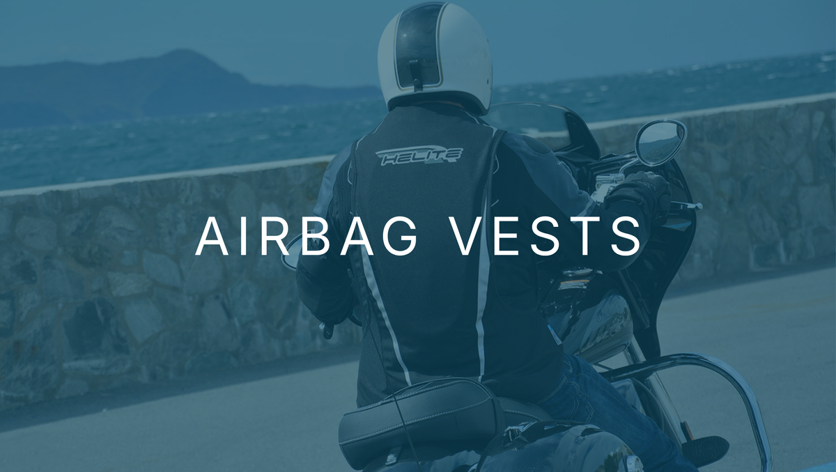 Motorcyclist on a coastal road wearing a Helite airbag vest over a jacket