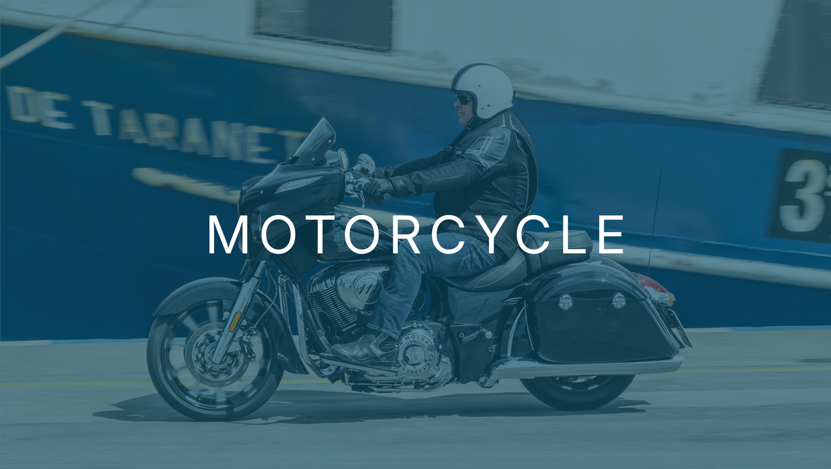 Motorcyclist riding past a moored boat wearing a Helite airbag vest