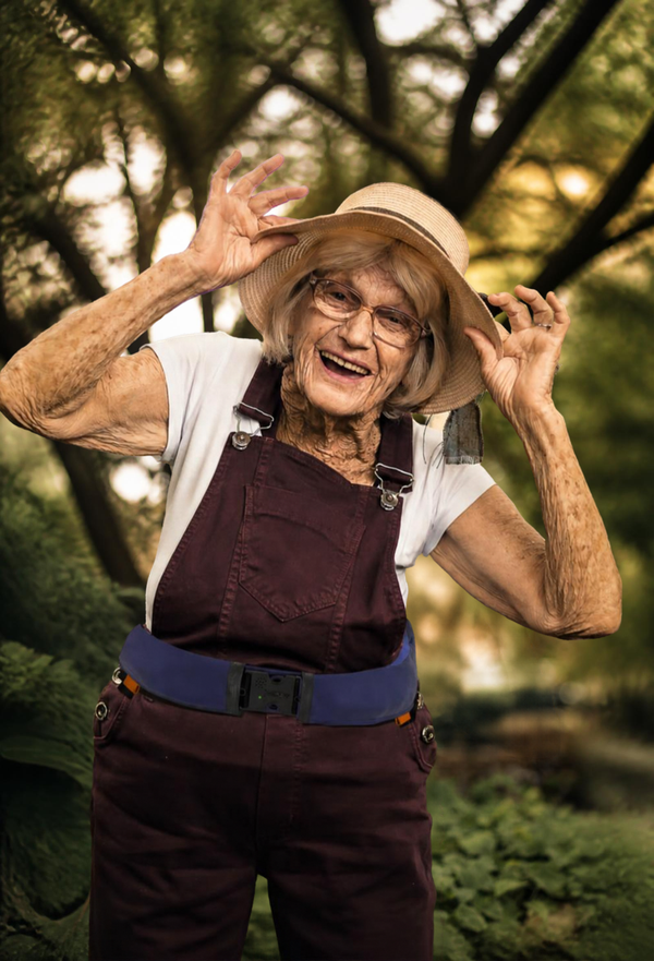 Smiling older woman in a sun hat wearing a Helite Hip'Guard airbag belt