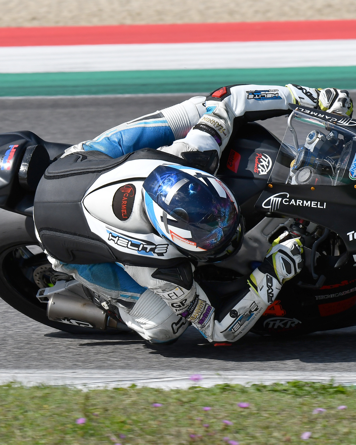Racer cornering on track in leathers with the Helite GP Air airbag vest
