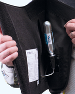 Hands opening the cartridge pocket of the GP Air vest to show the CO2 cartridge
