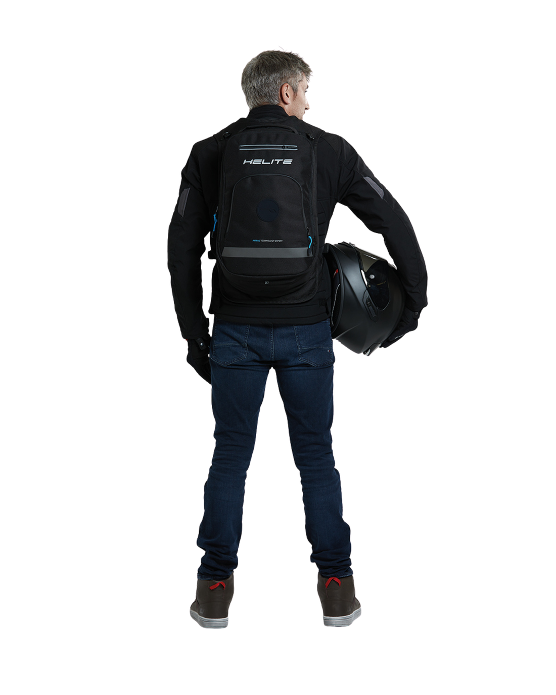 Man holding a helmet while wearing the Helite H-Moov electronic airbag backpack