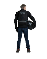 Man holding a helmet while wearing the Helite H-Moov electronic airbag backpack