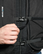 Close-up of a rider fastening the side buckle on the black Turtle 2 airbag vest