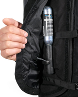 Hand fitting a CO2 cartridge into the pocket of the black Turtle 2 airbag vest