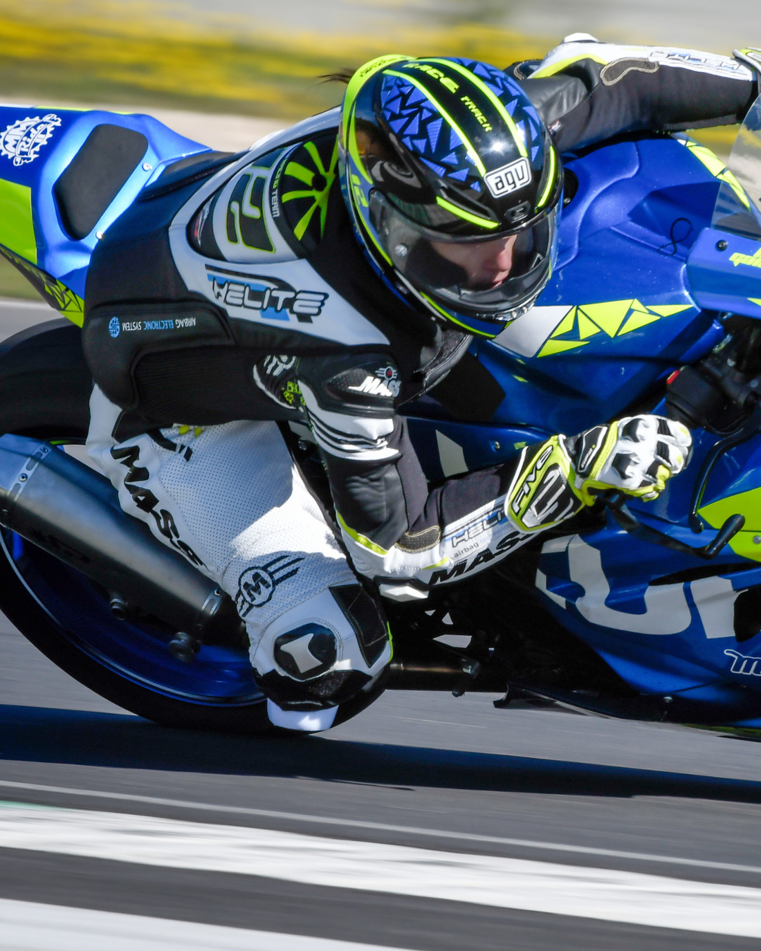 Racer cornering on track wearing the Helite e-GP Air airbag vest over leathers