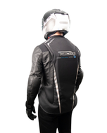 Rear view of a rider wearing the black e-Turtle airbag vest over a leather jacket
