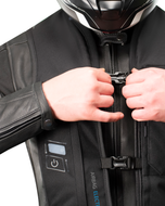 Rider fastening the front buckle of the black e-Turtle electronic airbag vest