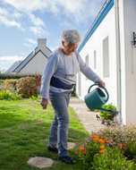 Older woman watering the garden while wearing the Helite Hip'Guard airbag belt
